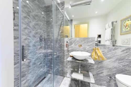 a bathroom with a glass shower stall and a sink at Hotel Kraft in Florence