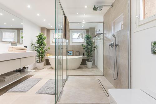 ein Badezimmer mit einer Badewanne und einer Dusche mit Topfpflanzen in der Unterkunft Designer Loft with Terrace in prime Location in Palma de Mallorca