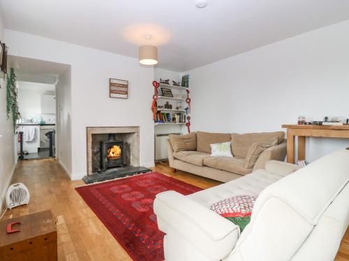 a living room with a white couch and a fireplace at Knightsward Farm in Anstruther
