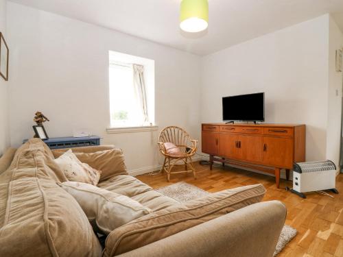 a living room with a couch and a television at Knightsward Farm in Anstruther