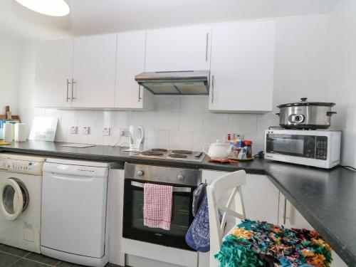 a kitchen with white cabinets and a stove top oven at Knightsward Farm in Anstruther