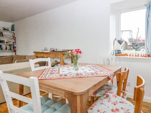 a dining room table with a vase of flowers on it at Knightsward Farm in Anstruther