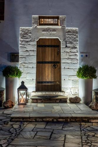 a wooden door in a stone building with a lantern at Mountain's Secret in Mouresi