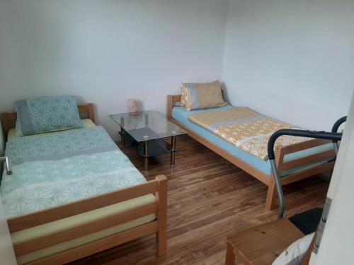 a room with two beds and a table at Wohnung Rheintal im Alpenvorland in Batschuns