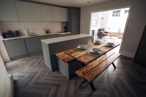 a kitchen with a wooden table and a dining room at The Dunes, Lytham St Annes in Lytham St Annes