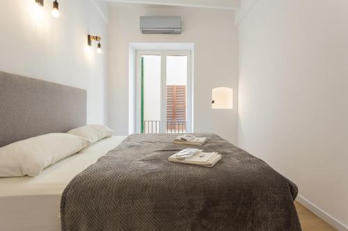 a white bedroom with a bed and a window at Designer Loft with Terrace in prime Location in Palma de Mallorca