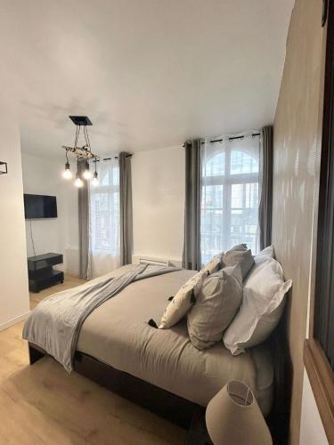 une chambre avec un lit avec des oreillers et une fenêtre dans l'établissement Appt 2 à deux pas de la gare d'Amiens, à Amiens