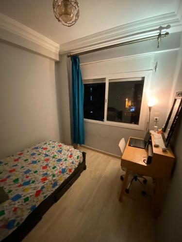卡薩布蘭卡的住宿－Fatimaresi，一间卧室配有一张床、一张书桌和一个窗户。