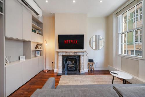 a living room with a fireplace with a sign above it at Superb One Bedroom Apartment in Soho in London
