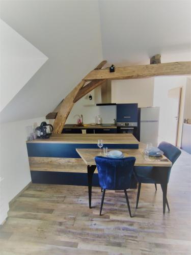 une salle à manger avec une table et une chaise bleue dans l'établissement The Moulin Brochat Loft with jacuzzi area, à Saint-Jean-de-Vaux