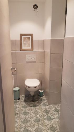 a bathroom with a toilet and a tile floor at Ferienwohnung Kaffestübchen 