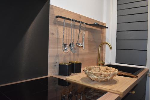 um balcão de cozinha com uma tigela e utensílios em Le Duclos, appartement rez-de-jardin Dinan centre em Dinan