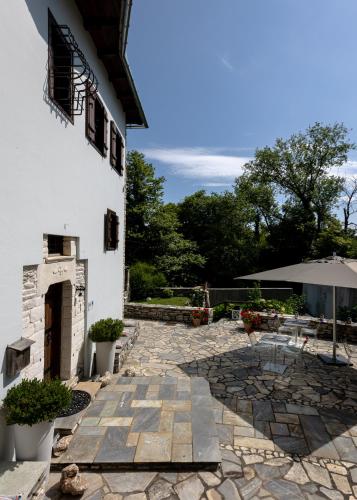 a stone patio with an umbrella next to a building at Mountain's Secret in Mouresi
