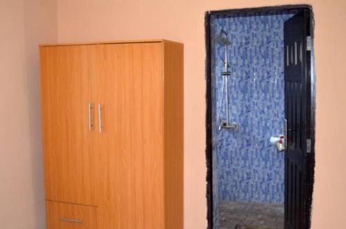 a mirror next to a wooden cabinet next to a door at Apartments Complex with Parking Ibadan Oluyole Extension - Sharp Corner in Ibadan