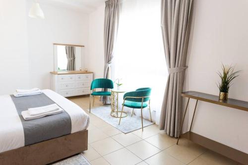 een slaapkamer met een bed en een tafel en stoelen bij MURJAN JBR Apartments by HAPPY SEASON in Dubai