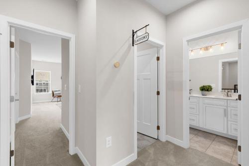 a hallway with white walls and a door with a sign on it at Luxurious 3 Story Townhome! The Dye at Barefoot Resort 402- Sleeps 12! in North Myrtle Beach