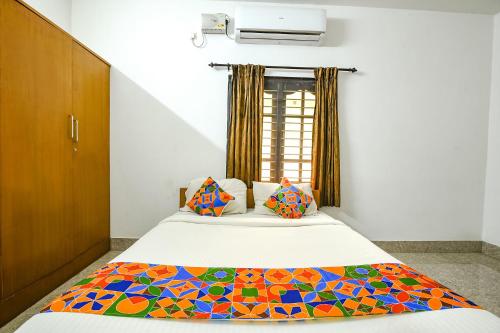 1 dormitorio con cama y ventana en FabHotel Joy's Residency en Coimbatore