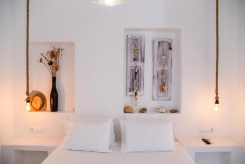 a bedroom with white walls and a bed with white pillows at Helmos Premium Studio in Naxos Chora