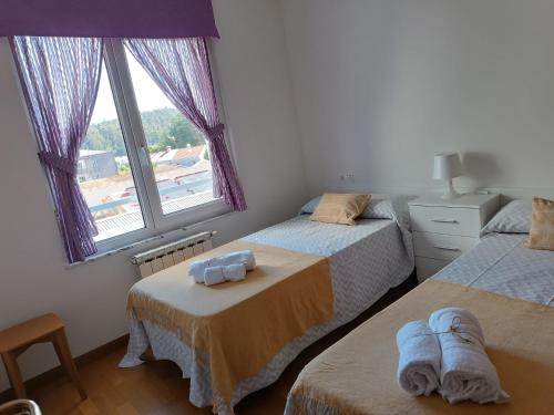 - une chambre avec 2 lits et une fenêtre dans l'établissement Recanto Milladoiro, à O Milladoiro