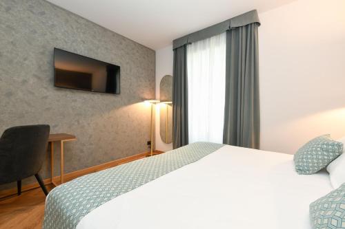 a hotel room with a bed and a television at Palazzo Santo Spirito in Bergamo