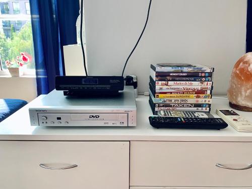 a desk with a computer and a stack of dvds at Apartament Esperanza in Sunny Beach