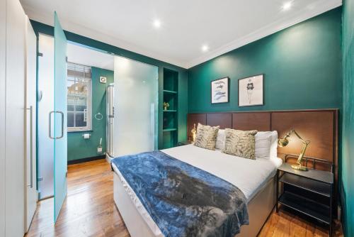 a bedroom with a bed and green walls at Fantastic One Bedroom Apartment in Soho in London
