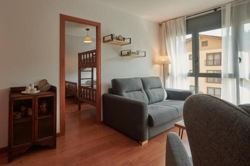 sala de estar con sofá y silla en Hauzify I Apartament Bella Molina en Alp
