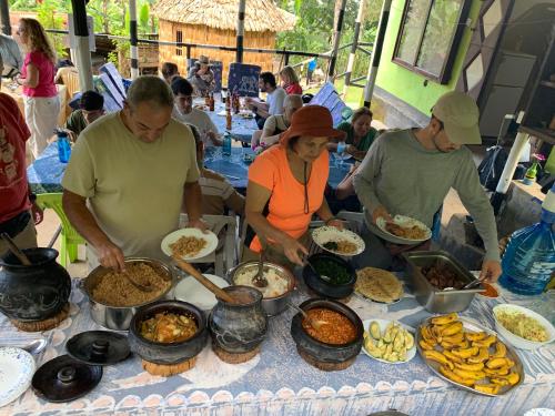 een groep mensen die eten bereiden op een tafel bij Machame Homestay and Cultural Tourism in Machame