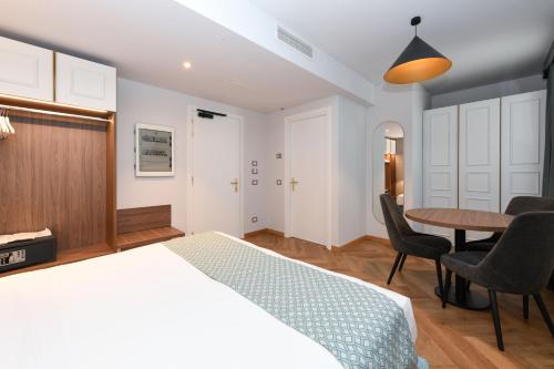 a bedroom with a bed and a table and chairs at Palazzo Santo Spirito in Bergamo