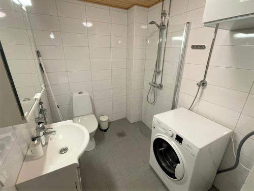 a bathroom with a washing machine in a sink at Kotimaailma - Tilava kaunis kaksio Myyrmäessä Vantaalla in Vantaa