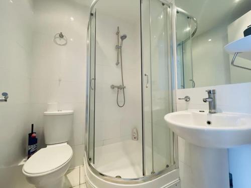 a bathroom with a shower and a toilet and a sink at The Hampstead Residence in London