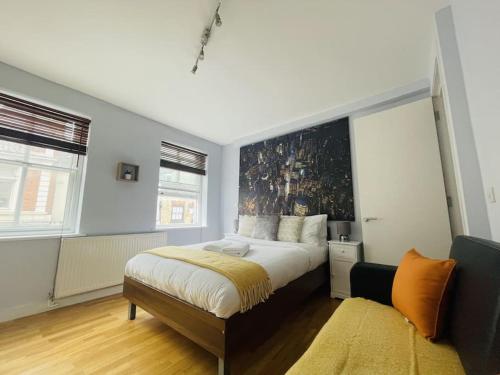 a bedroom with a large bed with a painting on the wall at The Hampstead Residence in London