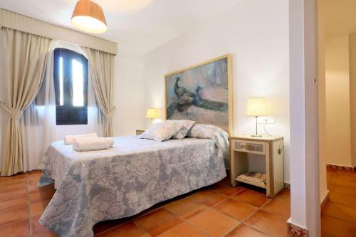 ein Schlafzimmer mit einem Bett und einem Wandgemälde in der Unterkunft Casa con encanto en la judería de Córdoba in Córdoba