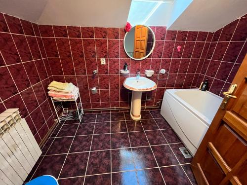 a bathroom with a sink and a tub and a mirror at Apartman D&D in Vukovar