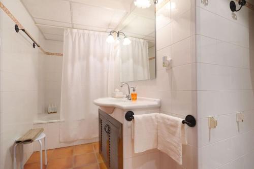 een witte badkamer met een wastafel en een douche bij Casa con encanto en la judería de Córdoba in Córdoba