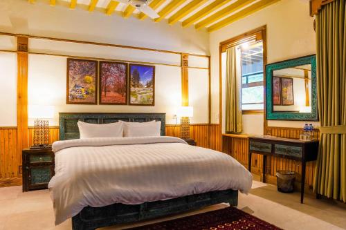 a bedroom with a large bed and a window at Greens By Roomy, Kalam in Kalām