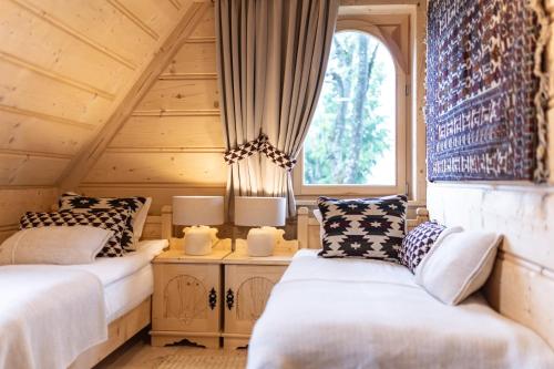 two beds in a room with a window at Villa Royal Zakopane in Kościelisko