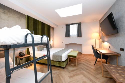 a hotel room with a bunk bed and a desk at Palazzo Santo Spirito in Bergamo