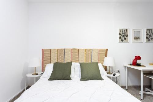 Una cama blanca con almohadas verdes en un dormitorio en EDEN RENTALS 106 Surfy Stylish Bed&Coffee Room en Granadilla de Abona