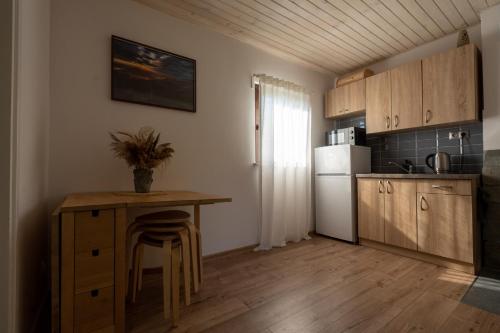 a kitchen with a small table and a refrigerator at Domki Jasicówka pod Łysą Górą in Limanowa