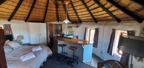 1 dormitorio con 1 cama y escritorio en una habitación en Mashai Rest Rondavel, en Underberg