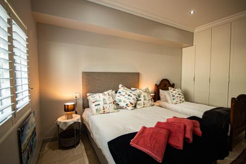 a bedroom with two beds with red towels on them at Walter’s Place in Jongensfontein
