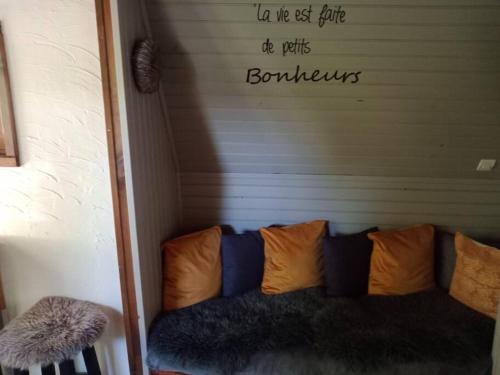 a couch in a room with a sign on the wall at Micro maison ISBA Sedan in Givonne