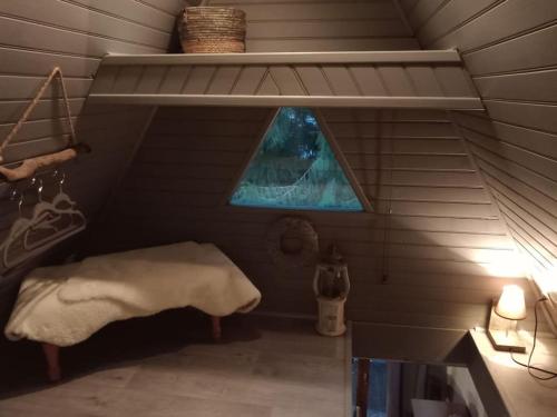 a attic room with a bed and a window at Micro maison ISBA Sedan in Givonne