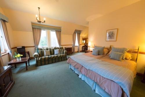 a large bedroom with a large bed and a couch at The Keepers in Aberfeldy