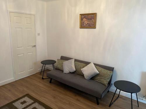 a living room with a couch and two tables at Isandula House in Nottingham