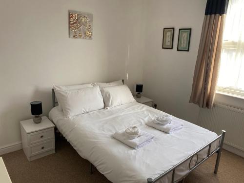 a bedroom with a white bed with towels on it at Isandula House in Nottingham