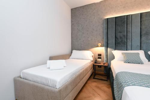 a hotel room with two beds and a table at Palazzo Santo Spirito in Bergamo