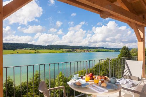 a table on a balcony with a view of a lake at Hotel Spa Les Rives Sauvages in Malbuisson
