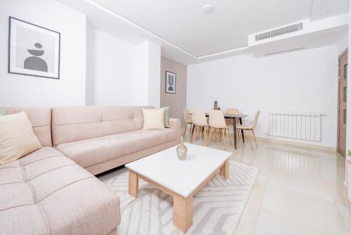 a white living room with a couch and a table at Appartement Luxueux à Kouba in Kouba